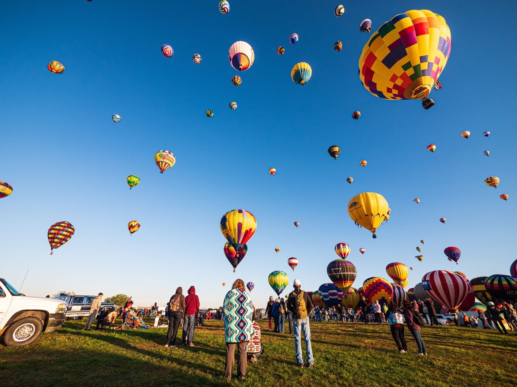 Hot air balloons rising over a field near Albuquerque at sunrise