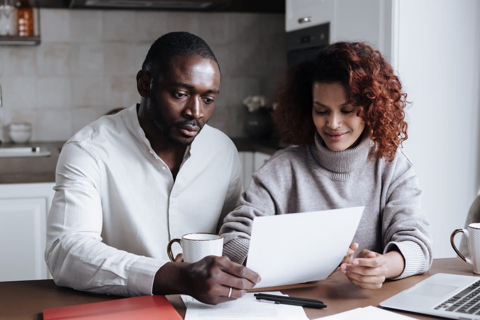 Couple reviewing household paperwork together at their kitchen table