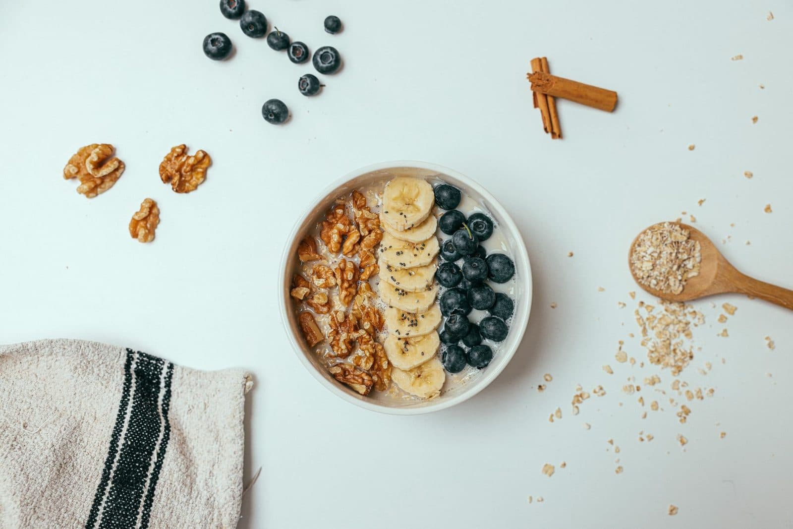 Oatmeal bowl topped with banana, blueberries and walnuts