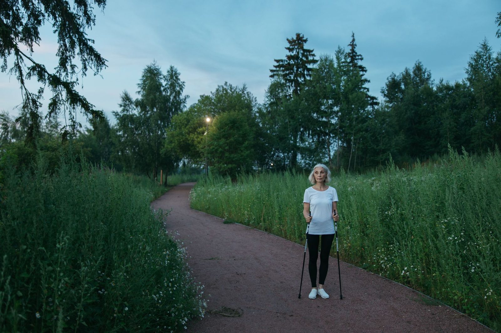 Older woman Nordic walking on a park trail